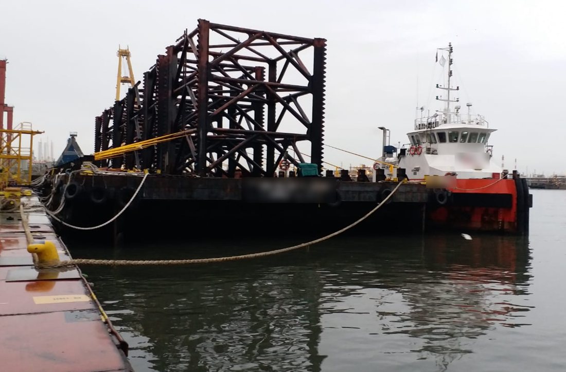 Tug and deck barge carrying an offshore structure